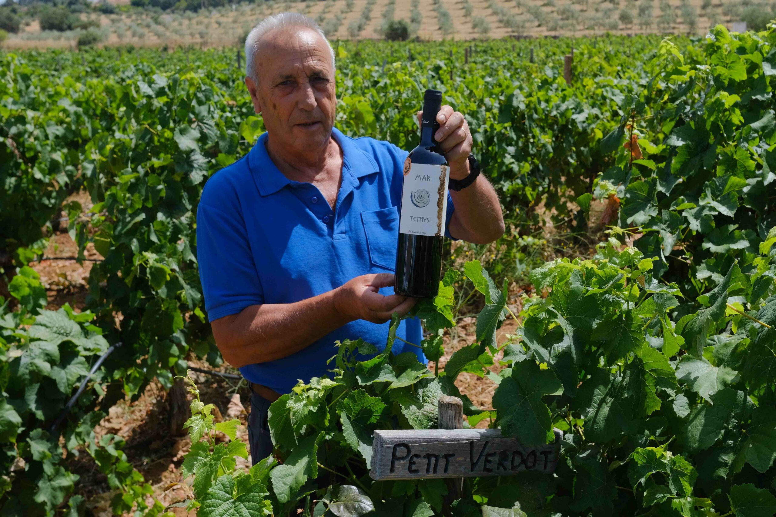 José Manuel Vetas mostrando una de las botellas junto al viñedo que lo hizo posible.